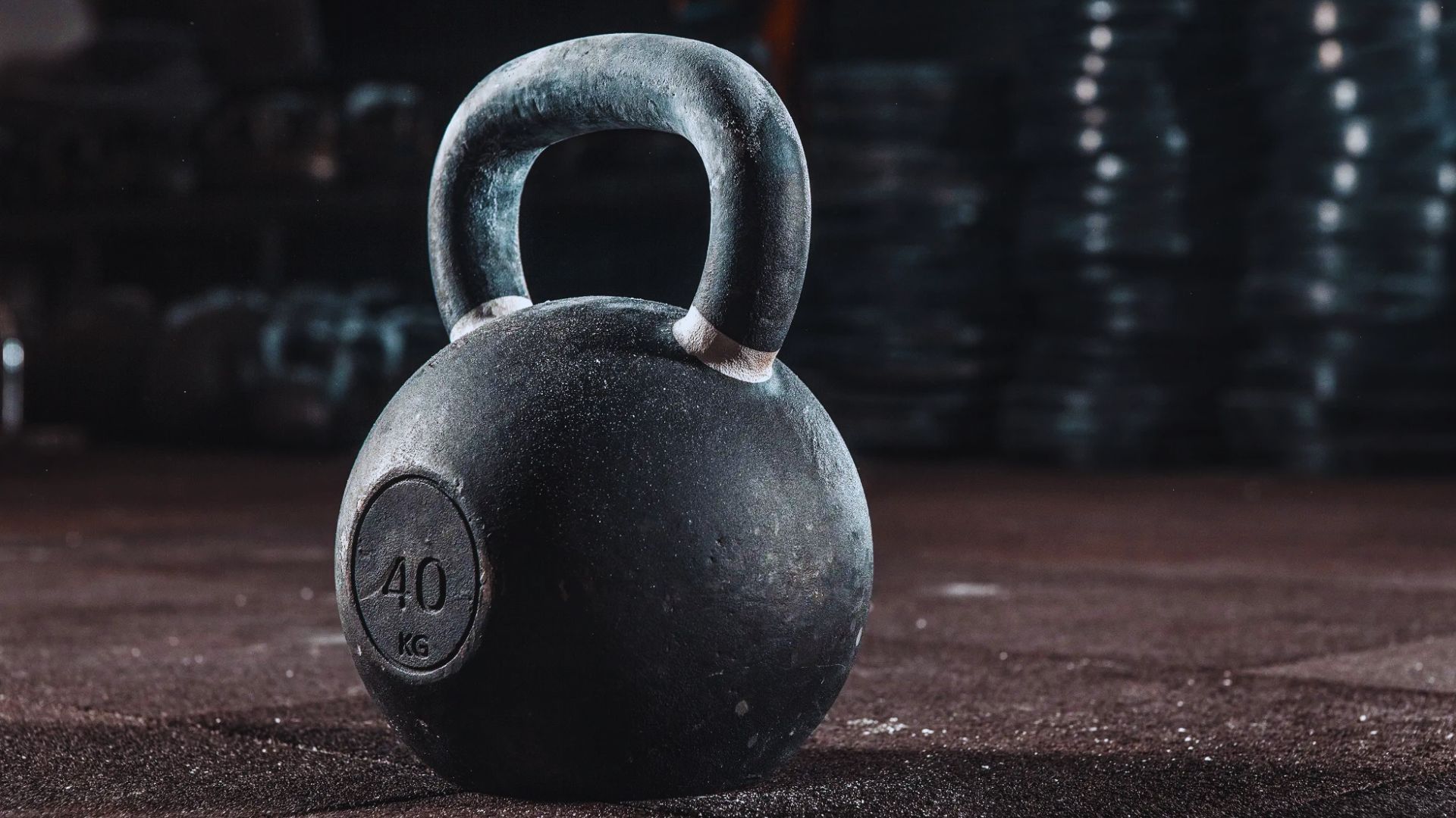 A black kettlebell rests on the ground, ready for use in a workout or strength training session.