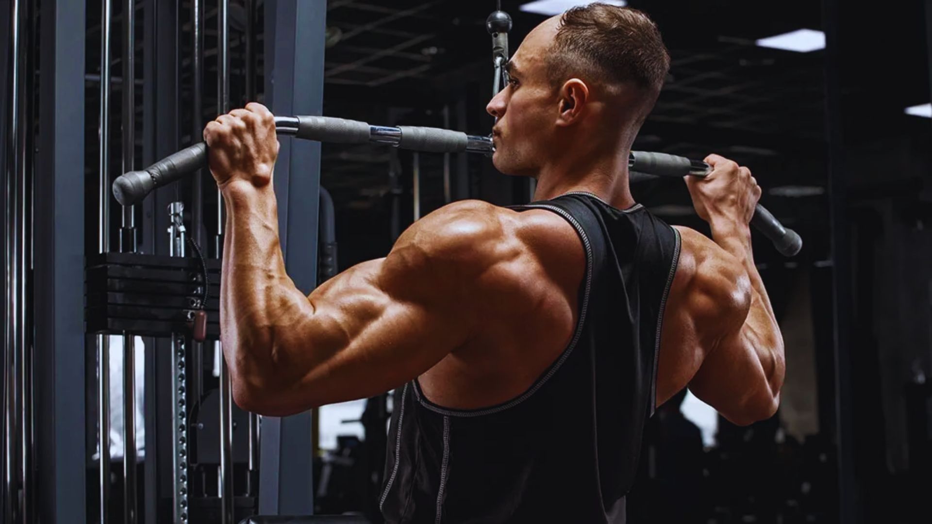 A man performs pull-ups on a bar in a gym, showcasing strength and fitness.