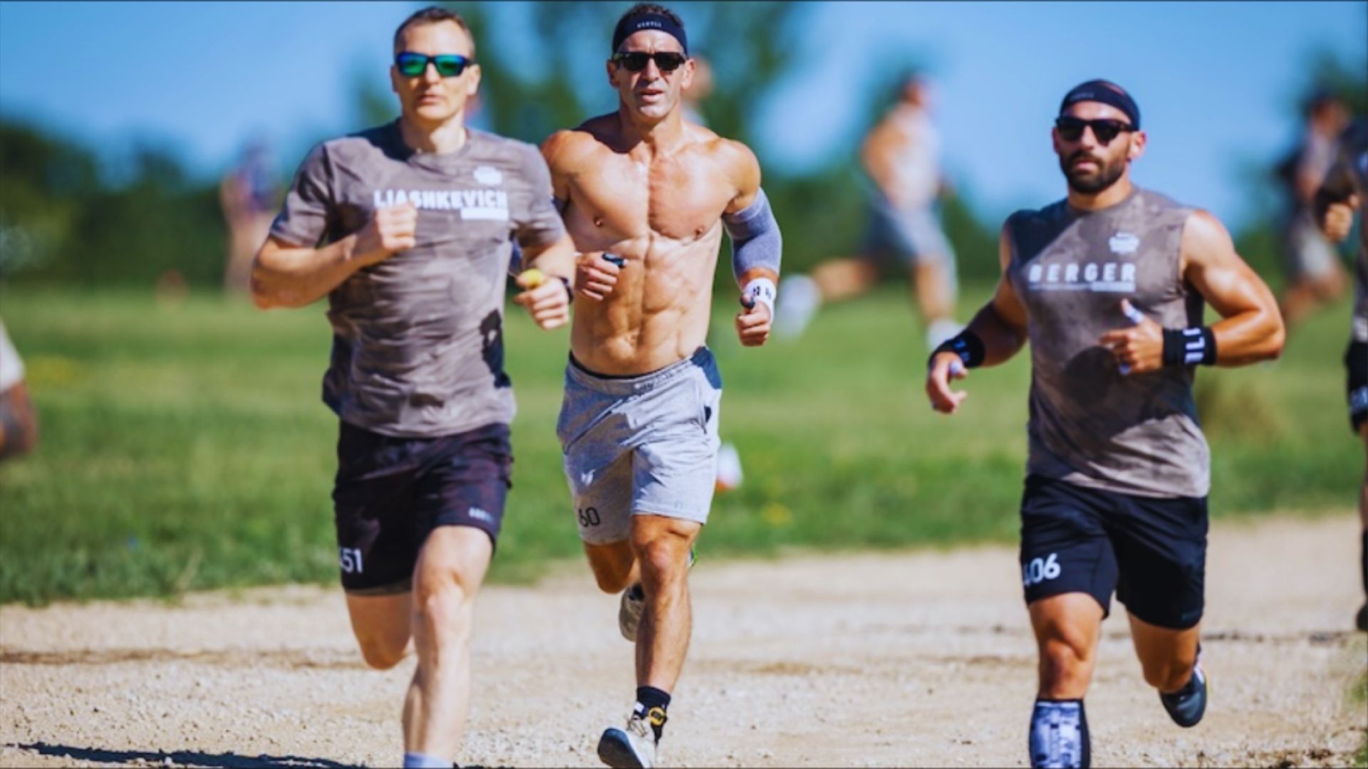 Three men sprinting along a dirt road, showcasing determination and athleticism.