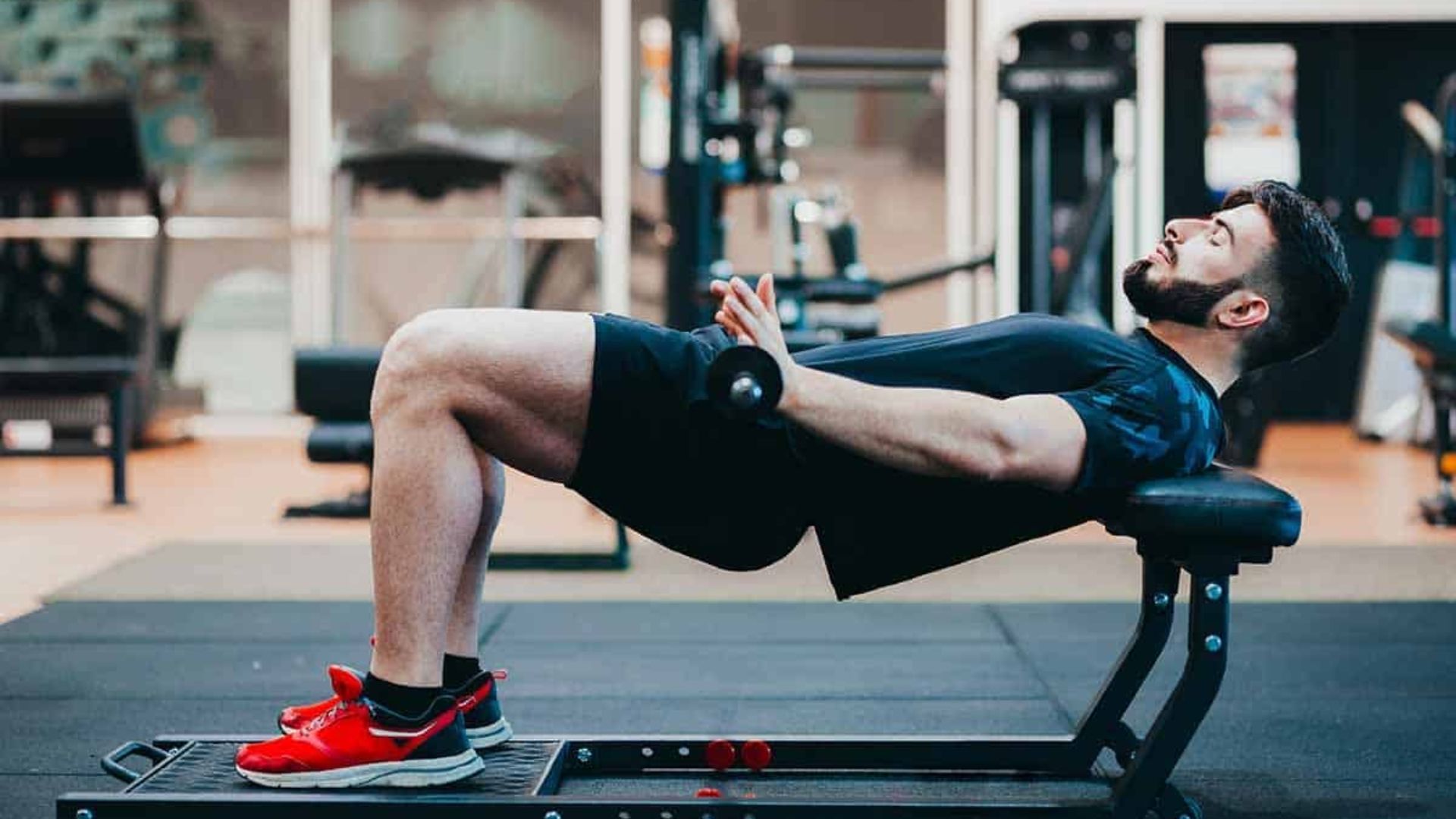 A man performs a sit-up on a bench, focusing on his core strength during a workout session.