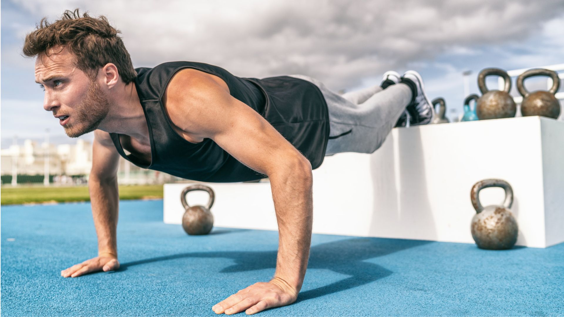 A man performing push-ups on a blue surface, focusing on his form and strength.