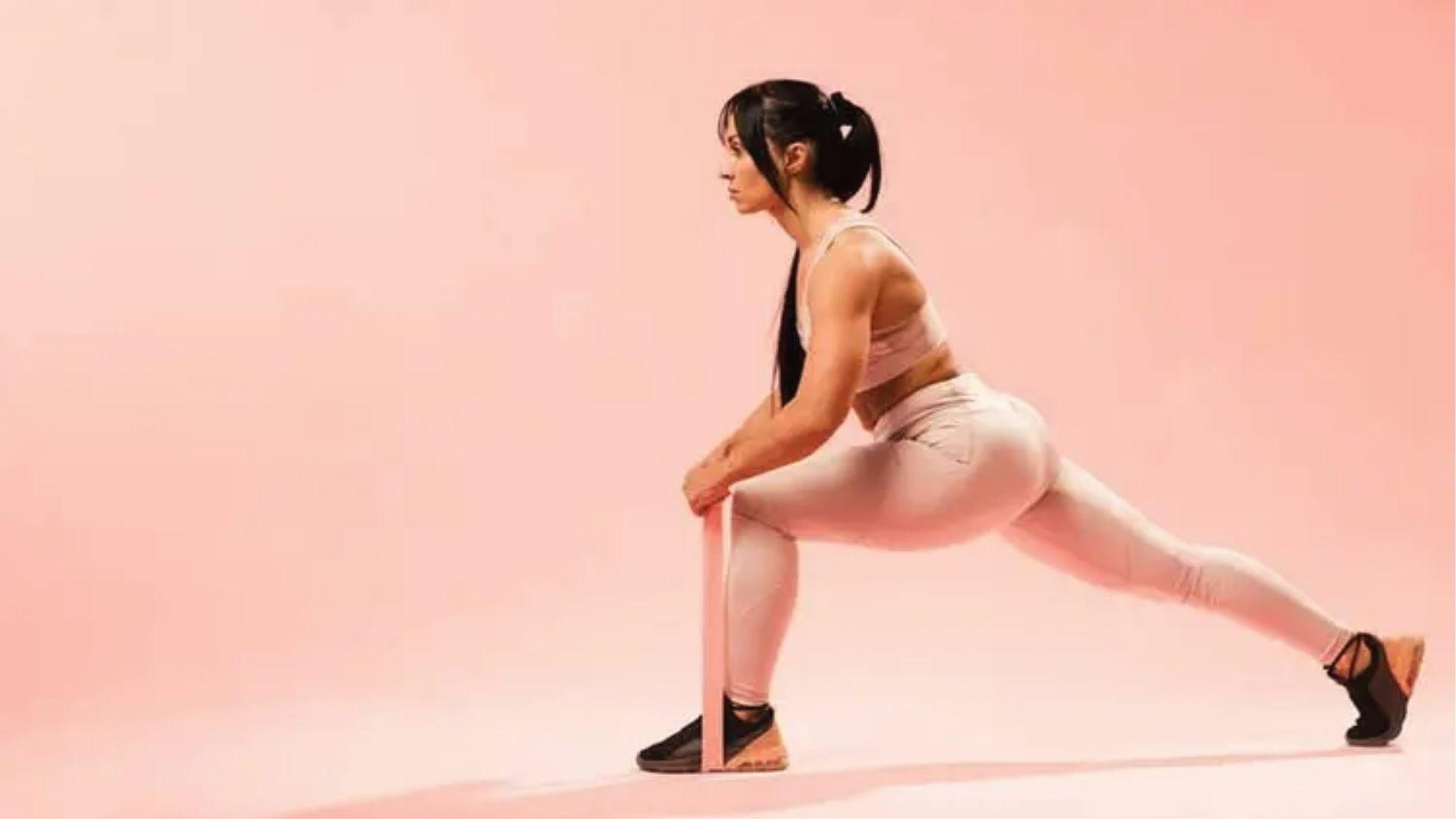 Woman in lunge with resistance band stretching hip flexors to target and strengthen glutes