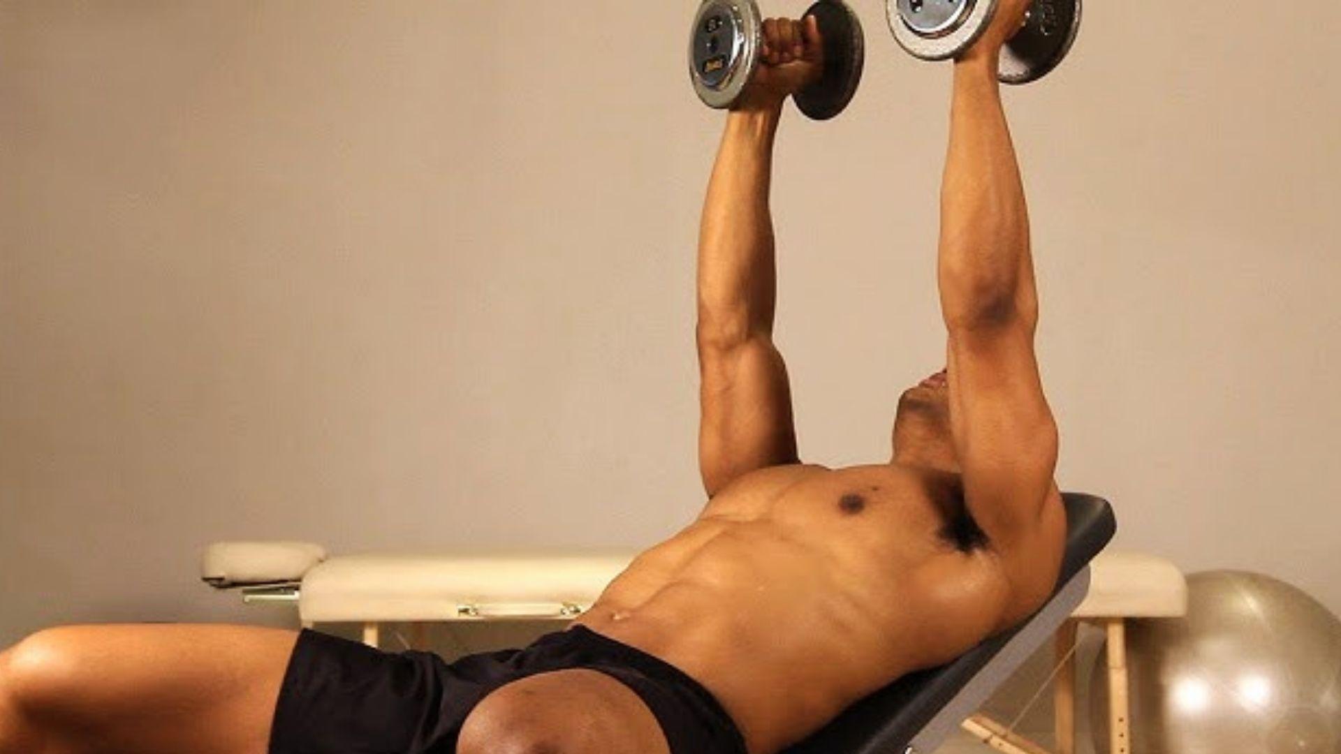 Person performing incline dumbbell fly on an incline bench targeting upper chest shaping and activation