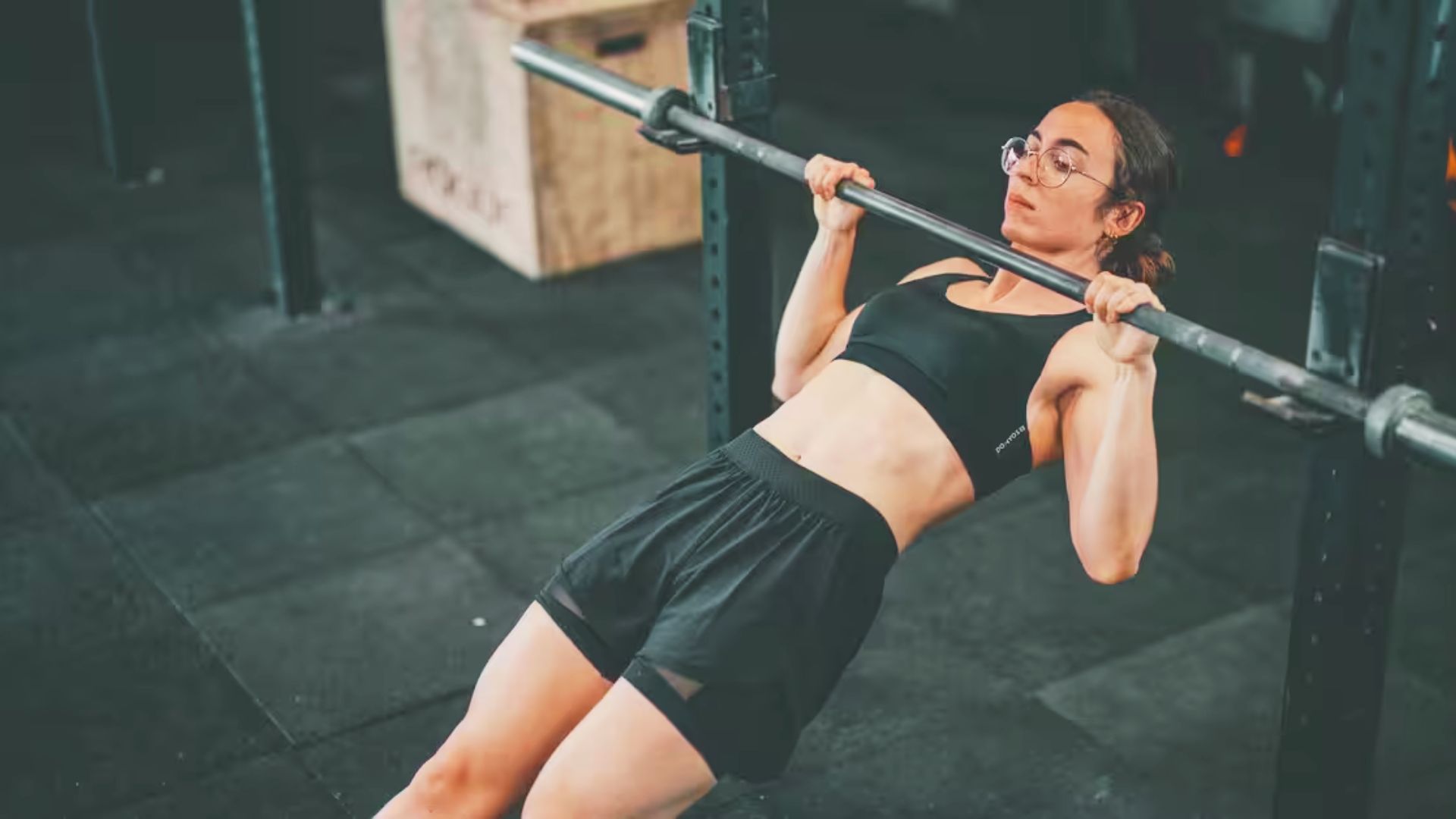 Woman lying face down on mat lifting arms in Y-position to engage upper back.