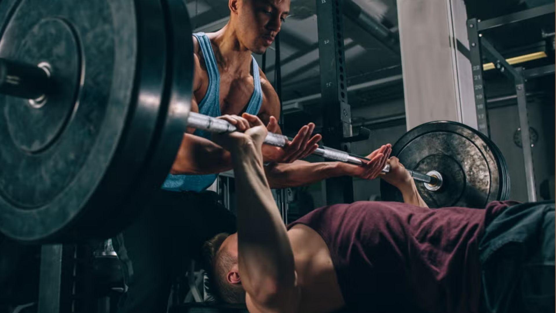 A person performing a bench press in the gym, representing strength benchmarks and tracking progress in lifting performance.