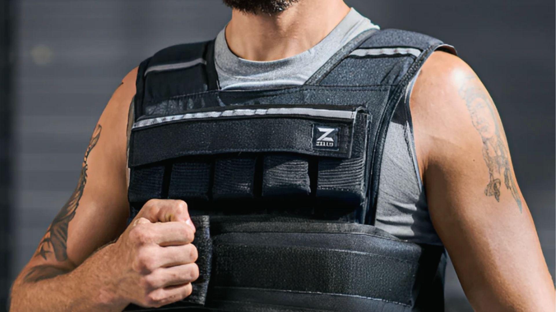 Close-up of man fastening black weighted vest with pockets to show how sizing affects comfort.