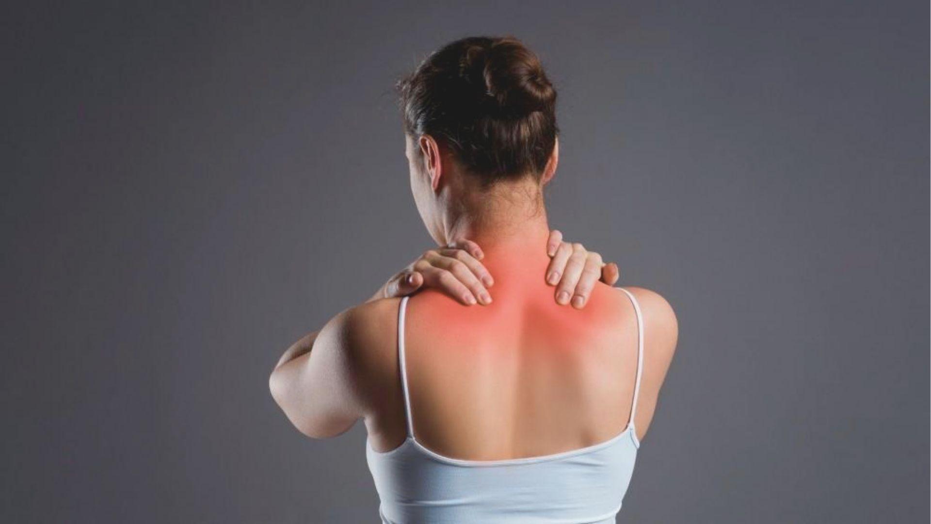 Woman in white tank top shown from behind with red highlight on upper back and neck.