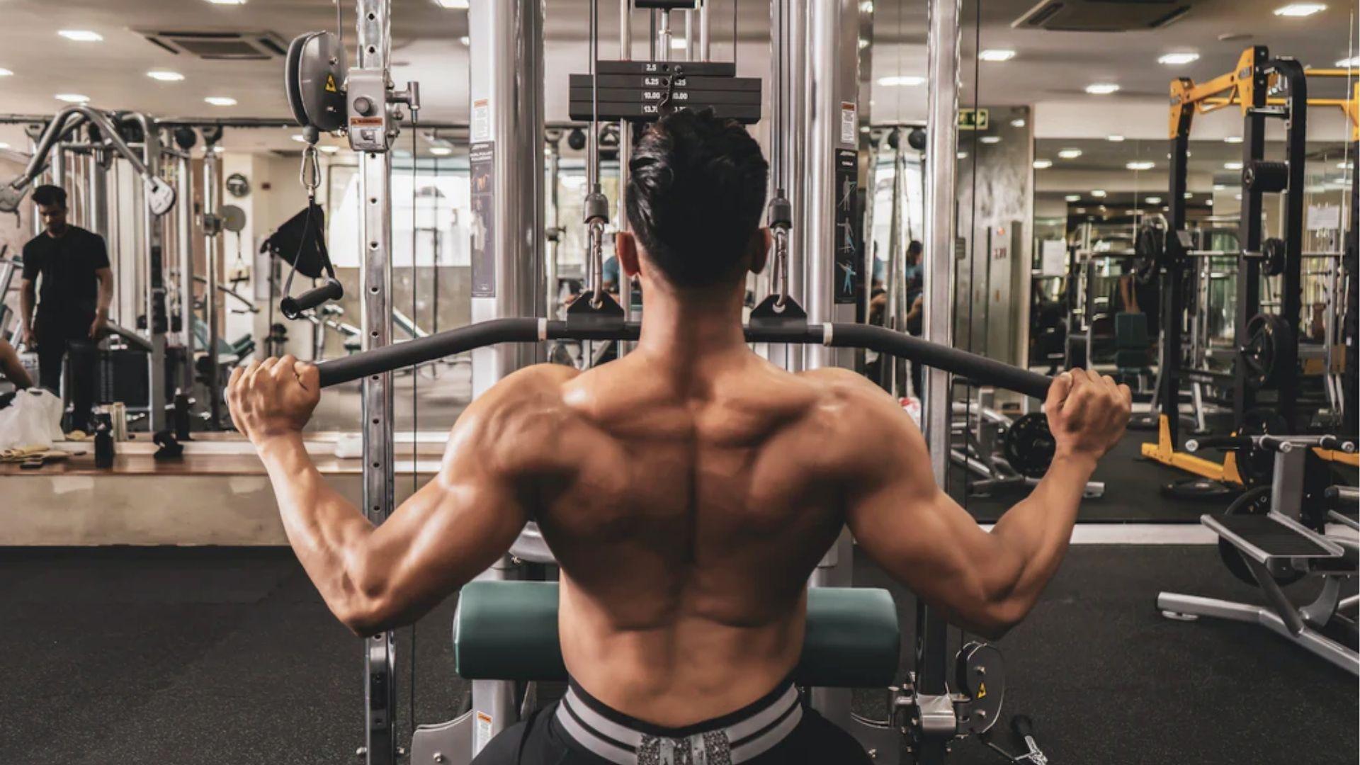 Person doing an upper back exercise using gym equipment.