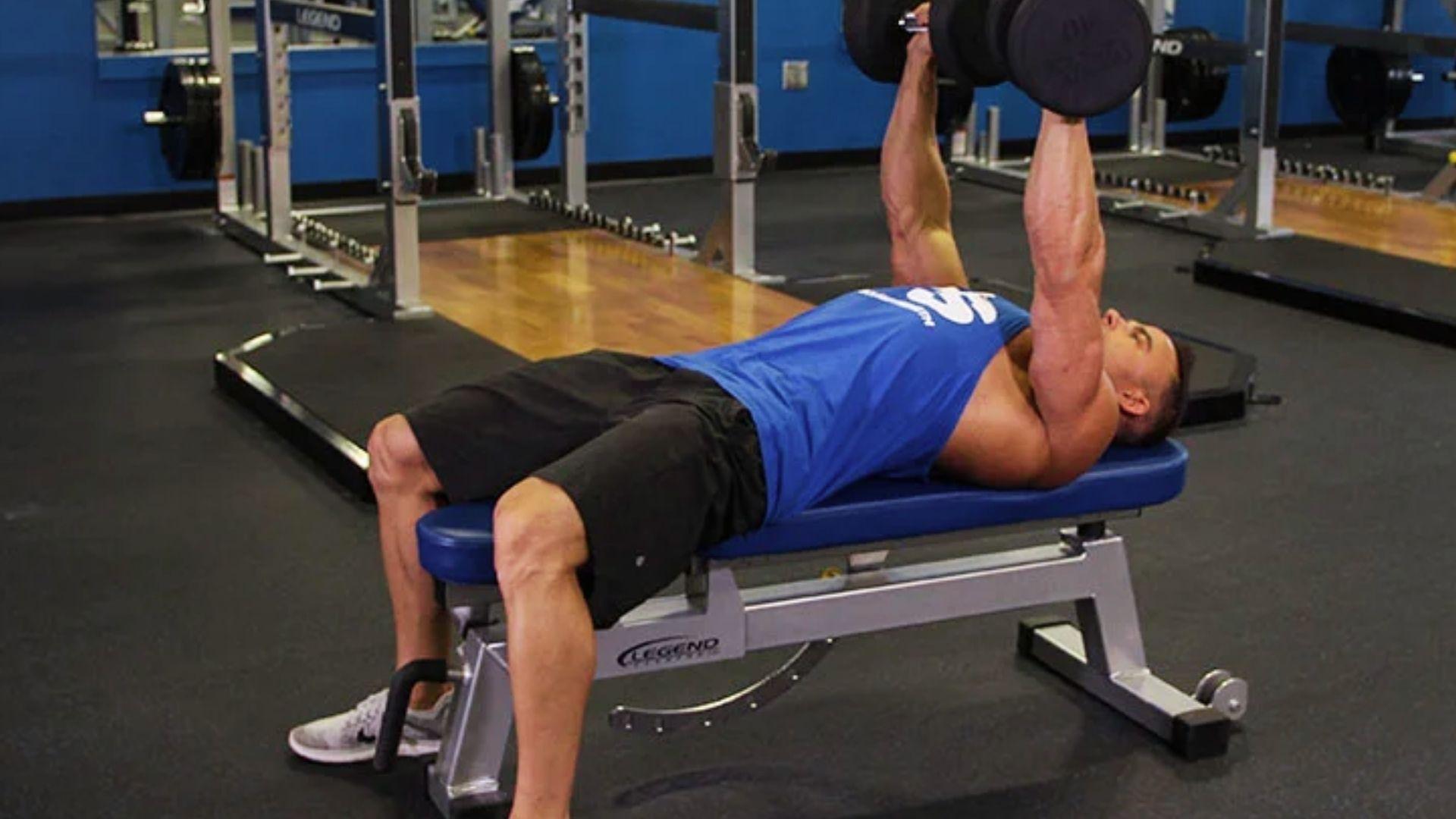 Person performing dumbbell flat bench press on a bench targeting overall chest muscle development