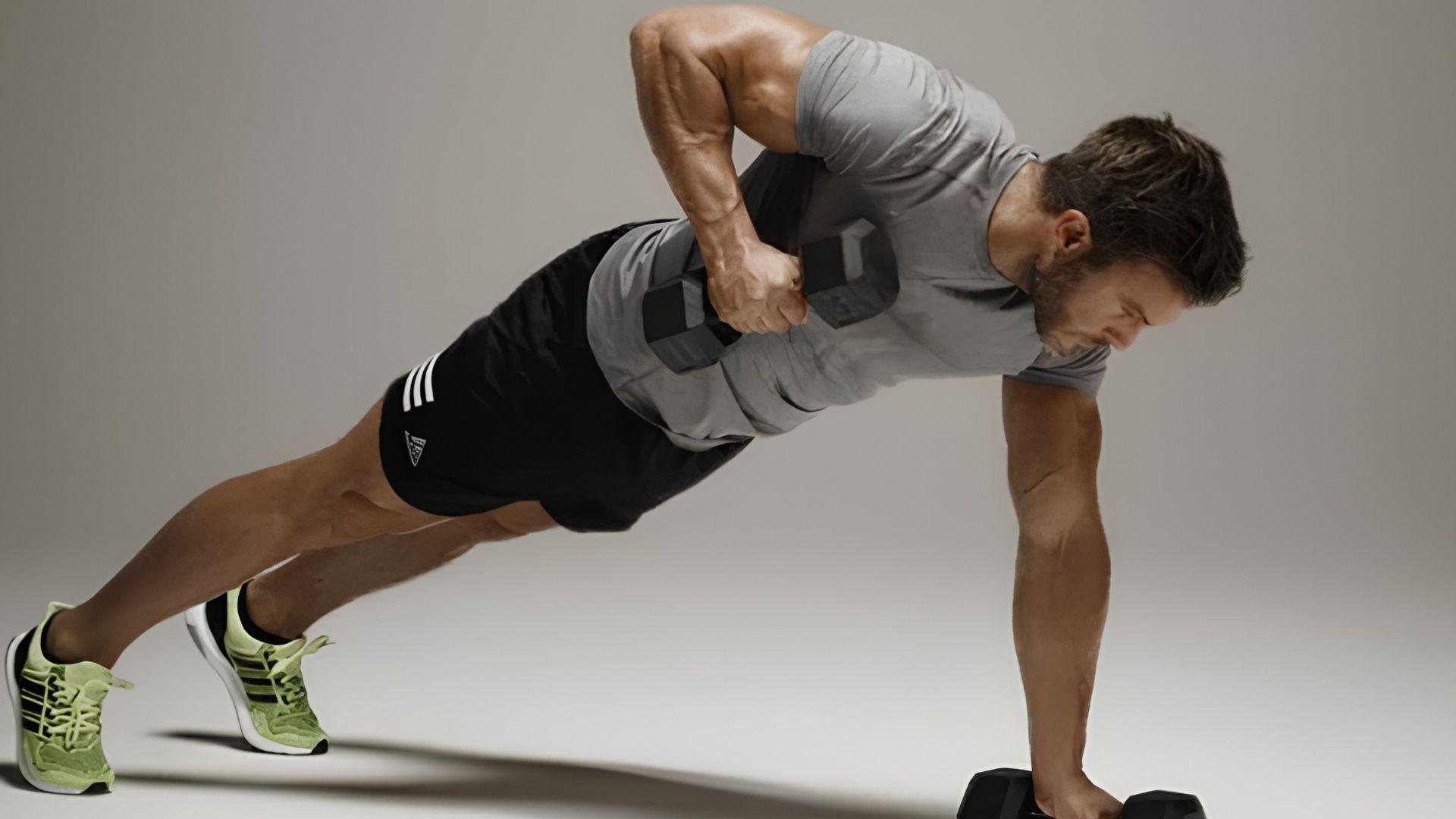 Person performing renegade push-ups with dumbbells engaging chest, core, and full-body stability