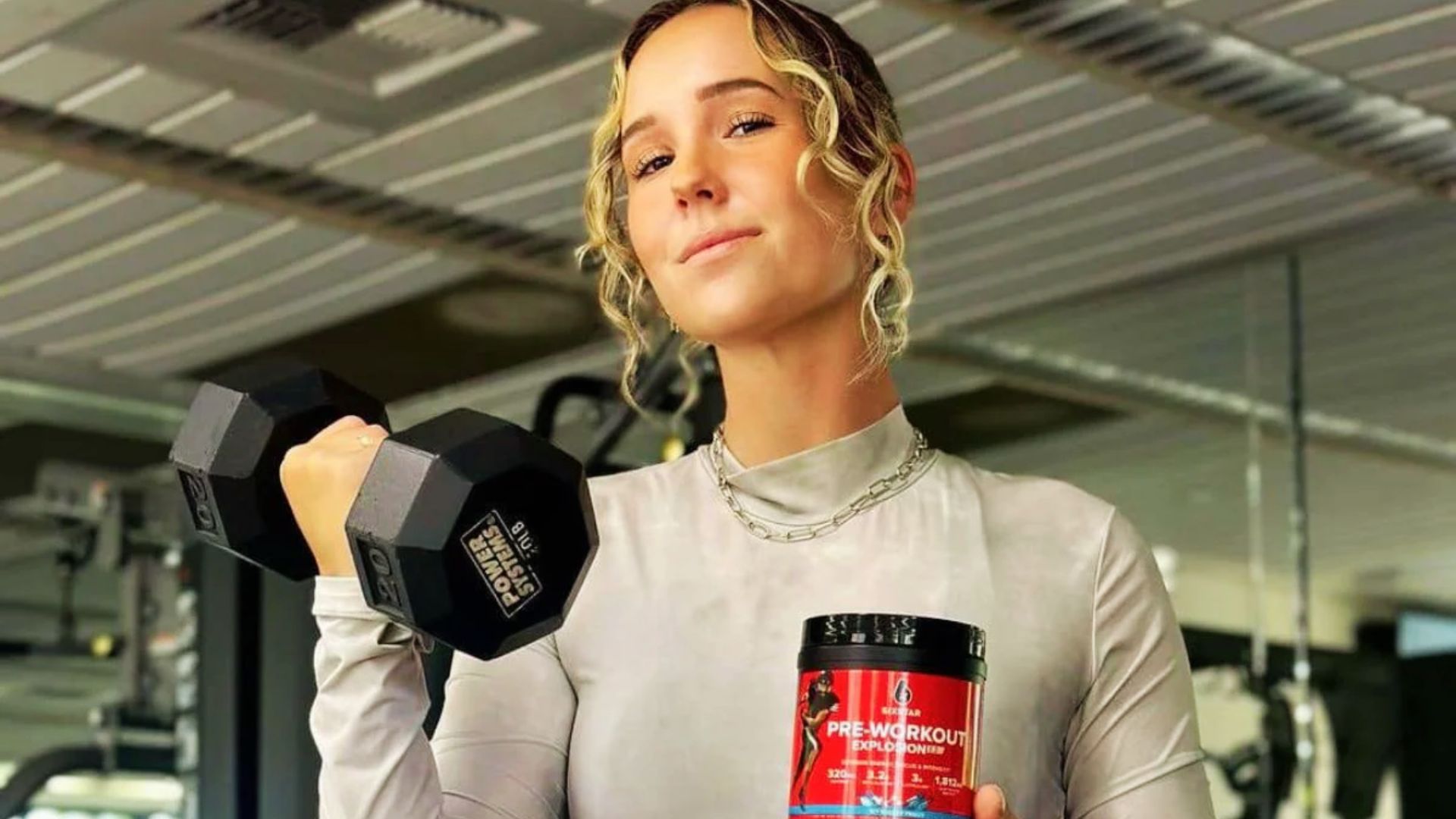 A person holding a pre-workout supplement before a gym workout, showing its role in energy and weight loss training.