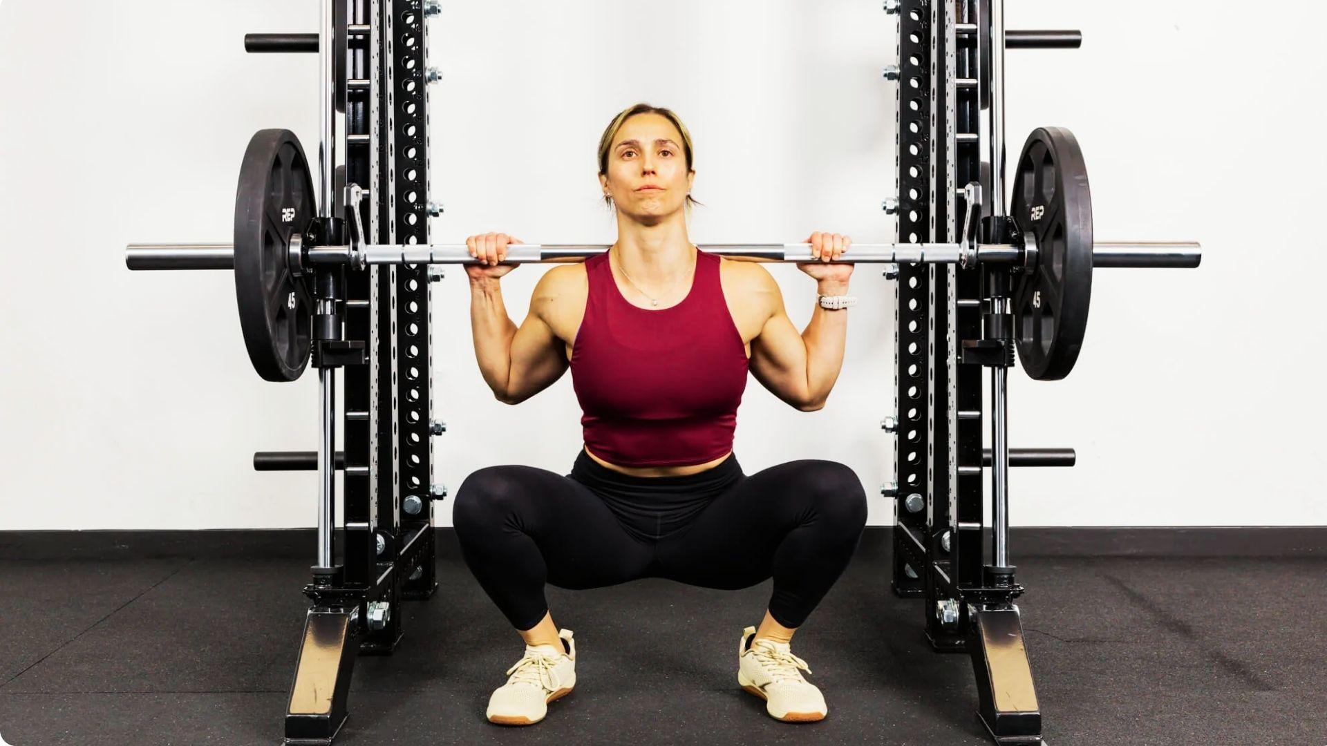 Athlete performing a squat on a Smith machine, maintaining stability while targeting the lower-body muscles.