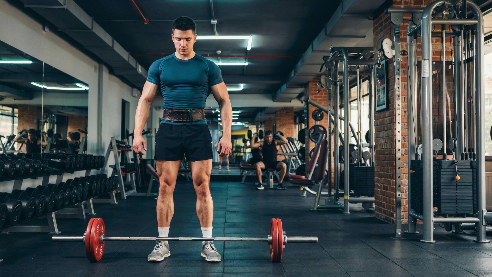 Man in gym shorts shows big upper body muscles but skinny legs, classic leg day neglect look.