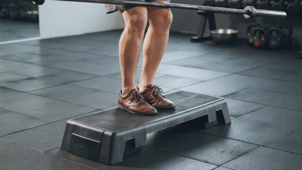 Athlete standing with heels elevated on a squat wedge before performing a squat.