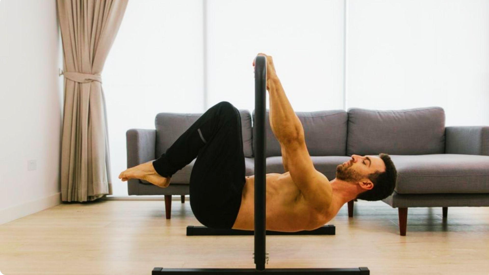 Athlete performing a tuck front lever on a pull-up bar with knees tucked and body held parallel to the floor.