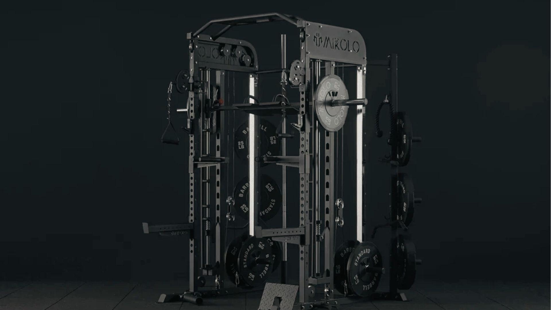 Mikolo Smith machine with loaded barbell showing how bar weight differs from Planet Fitness setup.