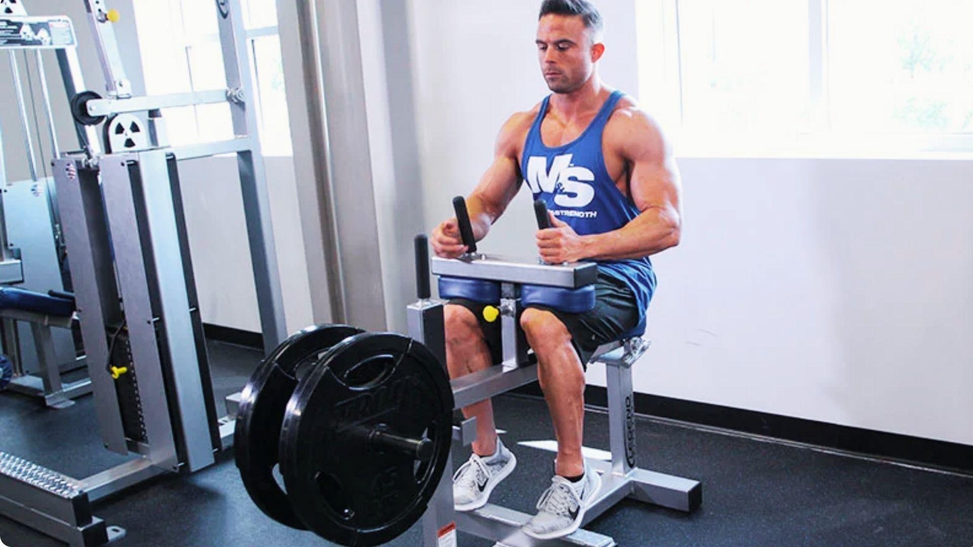 Athlete using a seated calf raise machine, lifting the heels to target the soleus and calf muscles.