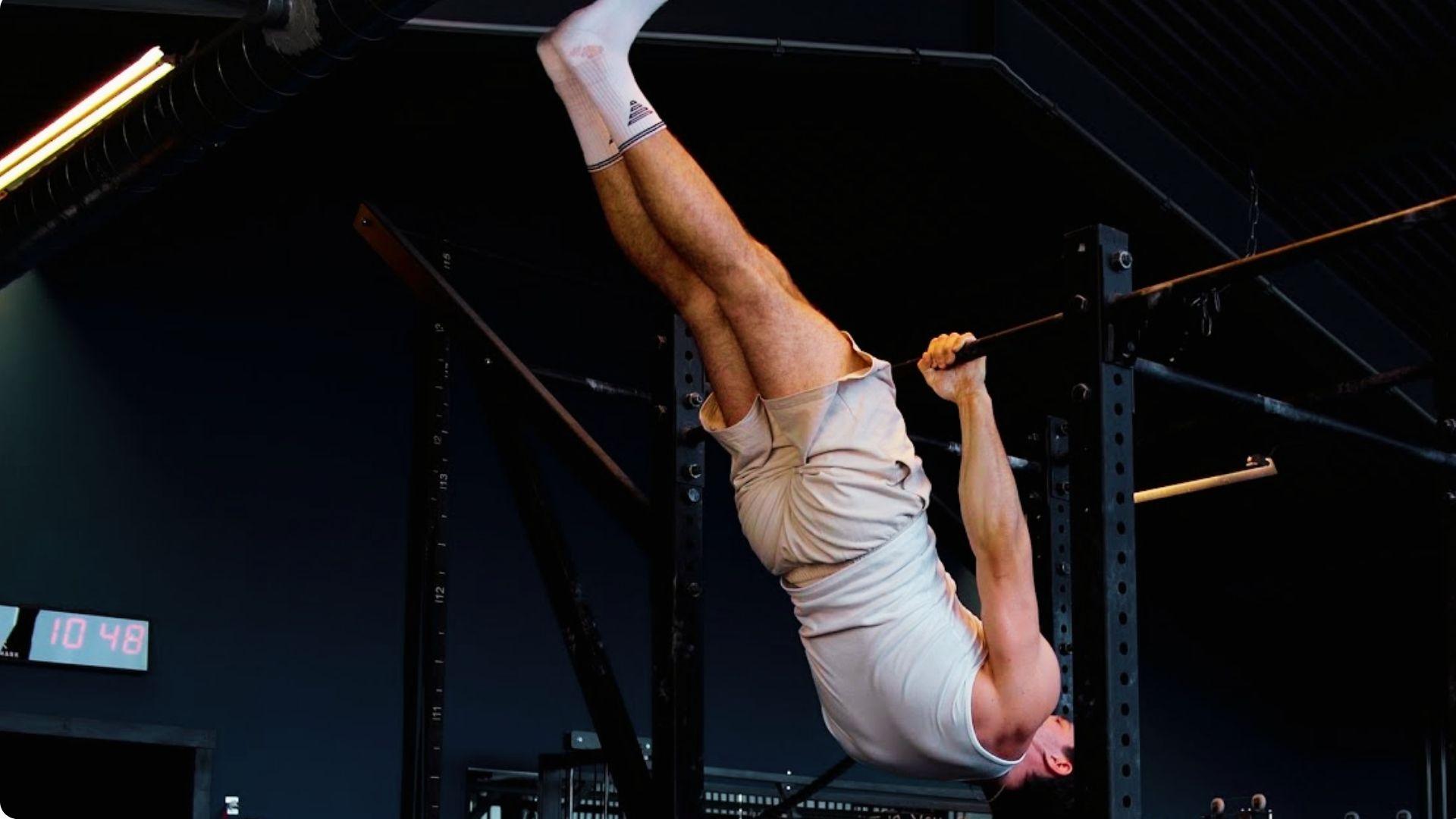 Athlete lowering from an inverted hang into a front lever position to build eccentric strength.
