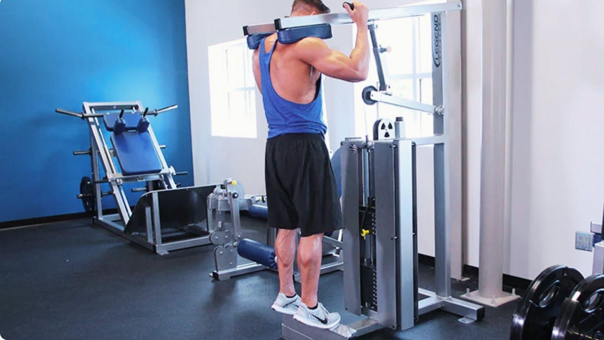 Gym-goer performing standing calf raises on a machine to strengthen the calf muscles and lower legs.