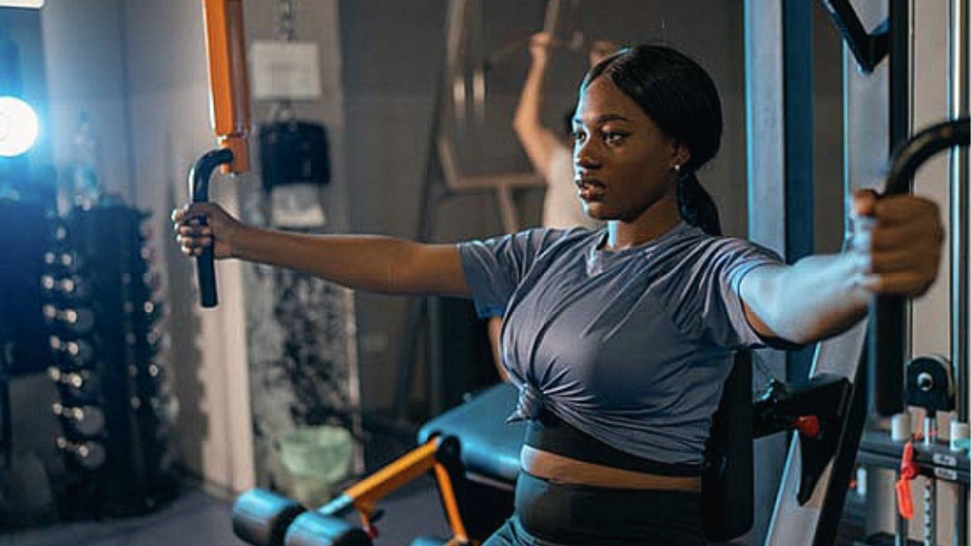 Woman using chest fly machine in gym to activate pectoralis major for strength and function