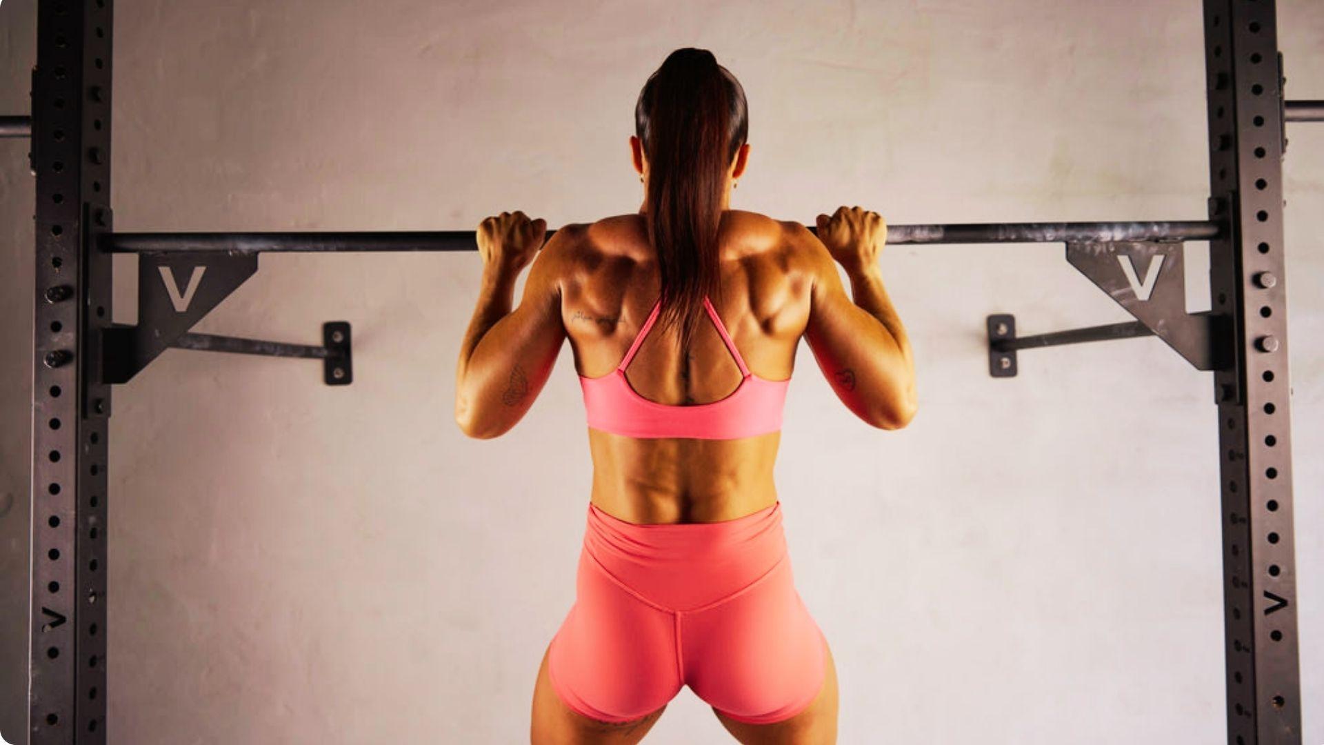 Athlete performing a pull-up by pulling the body upward until the chin clears the bar.