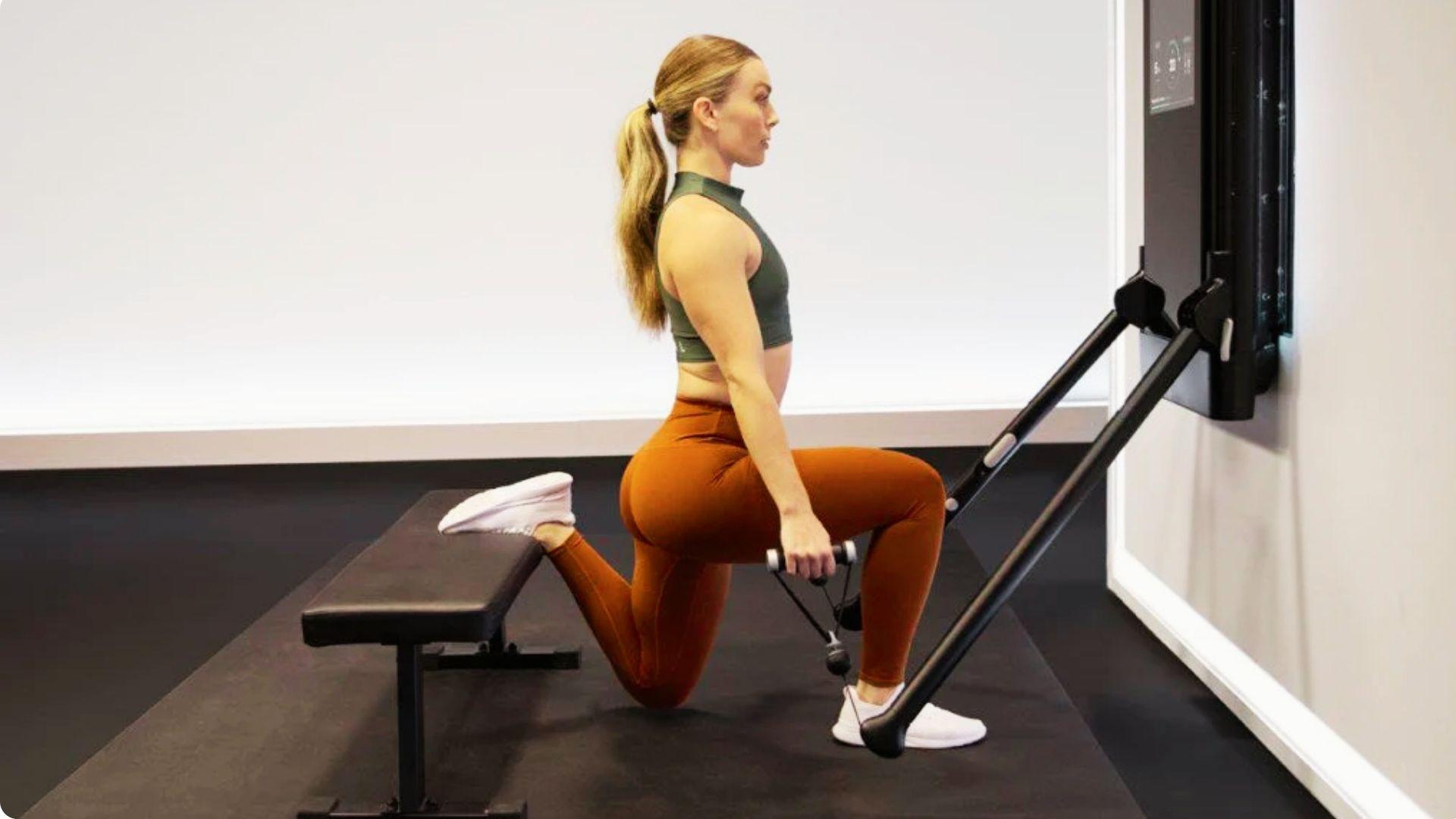 Athlete performing a Bulgarian split squat with one foot elevated on a bench and the other planted firmly on the floor.
