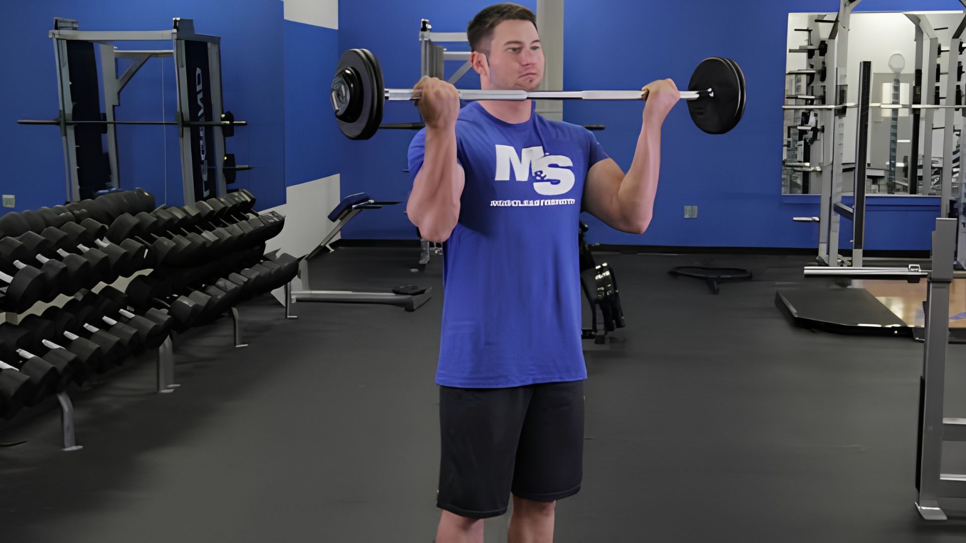 Man performing dumbbell hammer curls in a gym to target the biceps and forearms
