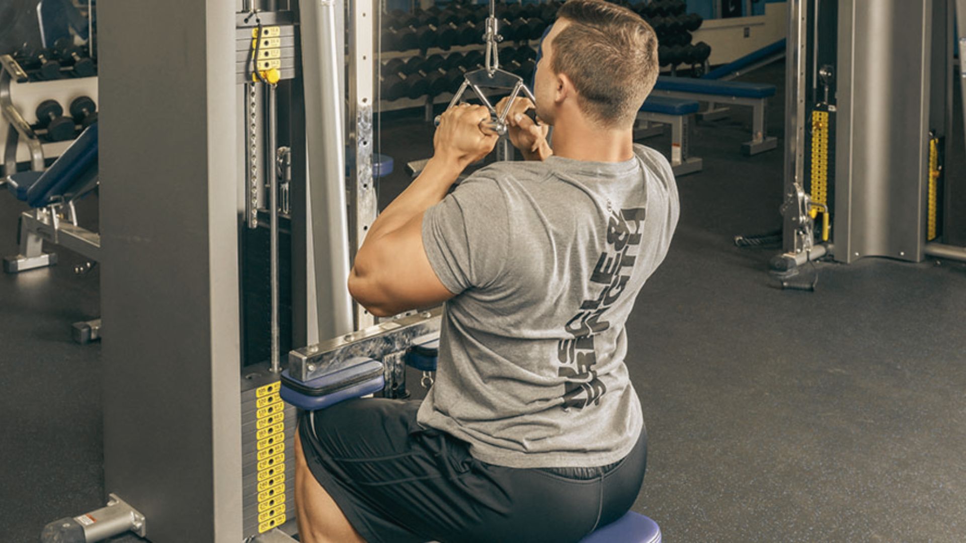 Man in a gray shirt executing a close-grip lat pulldown using a V-bar attachment.